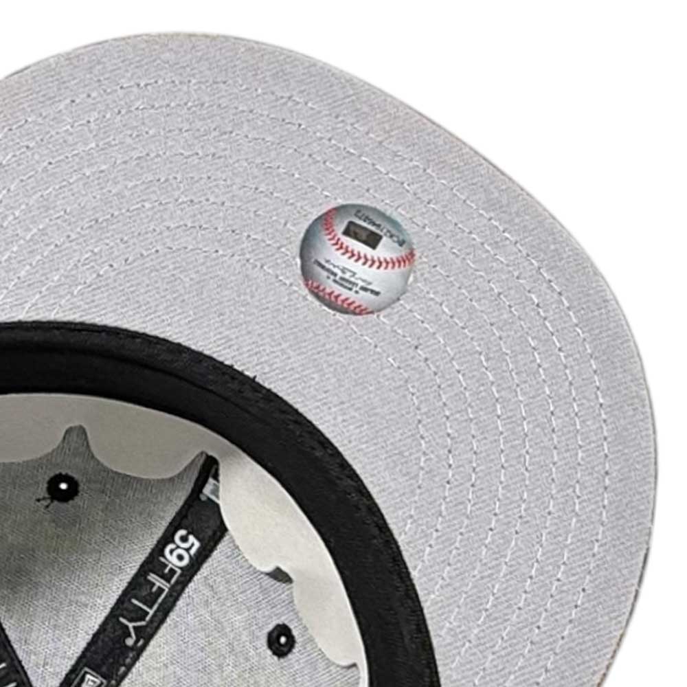 Close-up of the underside of a Fleck Black True Houston Astros New Era 5950 Fitted hat's brim, showing a small sticker with baseball details. The inside lining and part of the Astros logo are also visible.