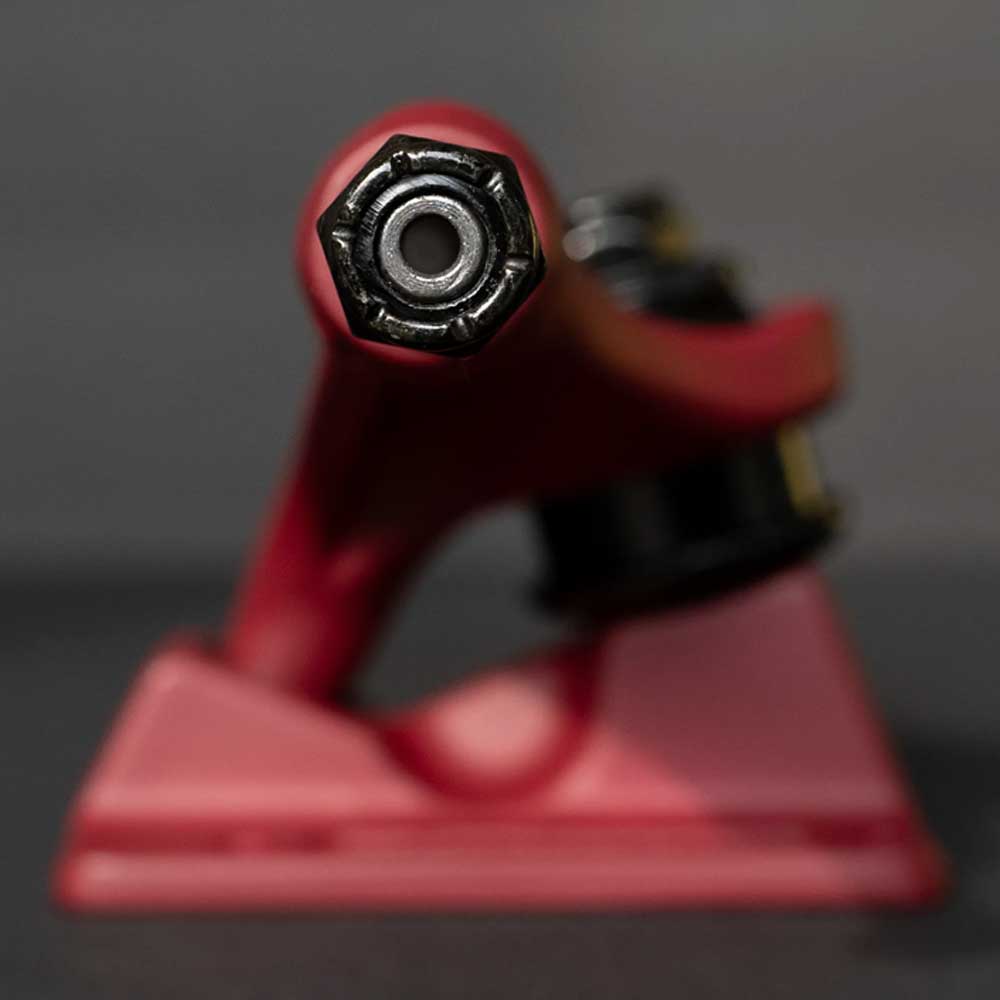 Close-up of a Forged Hollow RTB FTR Burgundy Standard INDY 144 Stage 11 Truck, front view focusing on the kingpin nut; blurred background highlights these lightweight, durable aluminum skateboard trucks (Set of Two).