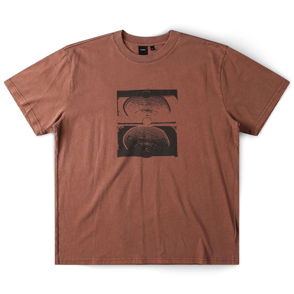 Crux Overdye Former Tee in Washed Bark—a brown short-sleeve t-shirt made from premium jersey cotton, showcasing a black abstract graphic with two vertically stacked semicircular, wave-like designs screen printed on the chest. The shirt is displayed flat against a white background.