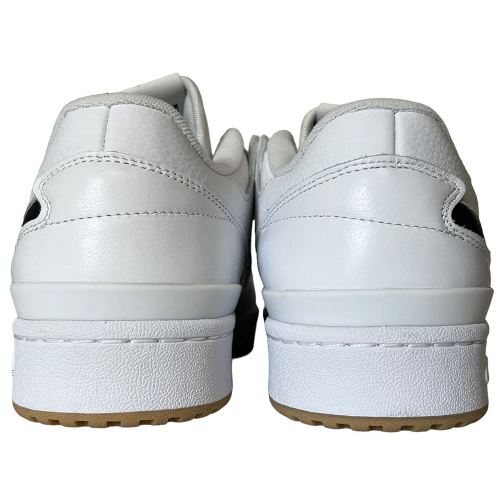 Rear view of Forum 84 Low Adidas Skateboarding Cloud White/Core Black leather shoes with thick soles and light brown outsoles side by side. Smooth, clean uppers offer minimal detailing for a classic look on a plain background.