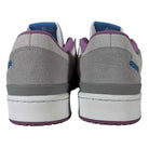 A close-up rear view of Forum 84 Low Adidas Skateboarding shoes featuring gray leather uppers, white midsoles, lavender accents on the collar and sole, and ice blue logo details on the heel.