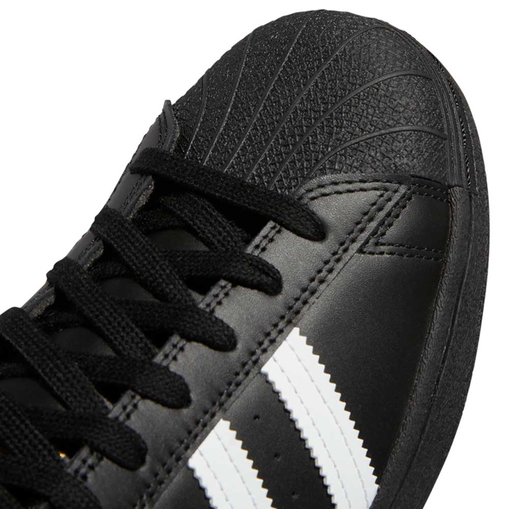 Close-up of the GW6931 Black White Superstar ADV Adidas Skateboarding leather shoe featuring white stripes, black laces, and a textured rubber toe cap—ideal for skateboarding.