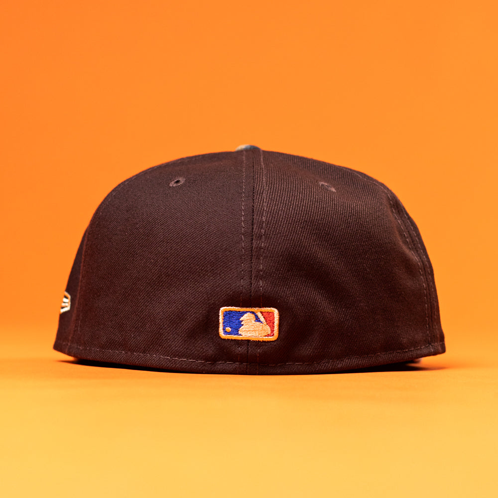 The Old Head RTC Wood Oil Houston Astros New Era Hat 5950 Fitted is shown from the back with an MLB logo patch, set against an orange background—a must-have cap for fans.