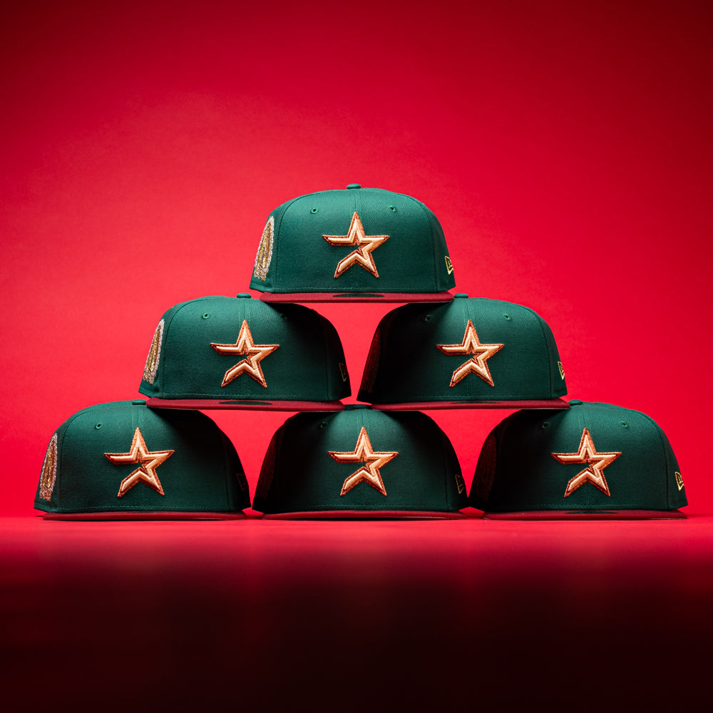 Five La Virgencita Green Red Gold New Era Houston Astros Hat 5950 Fitted caps, featuring vibrant green fabric with gold-outlined stars inspired by Mexican culture, are stacked in a pyramid shape on a red background.