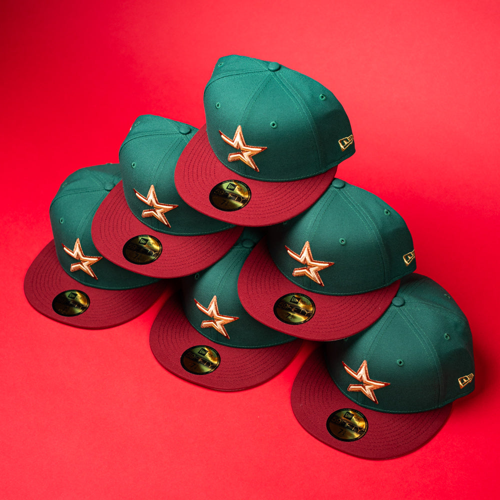 Six La Virgencita Green Red Gold New Era Houston Astros 5950 fitted hats are stacked in a pyramid shape on a bright red background, blending classic style with Mexican culture reminiscent of a Virgen-inspired design.