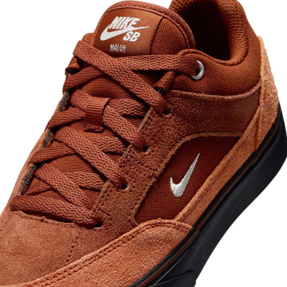 Close-up of HF1205200 Cinnamon Light Bone YOUTH Malor GS Nike SB Shoes featuring rust-colored suede, a white embroidered Swoosh, Nike SB logo on the tongue, and a black sole—ideal durable sneakers for young skaters.