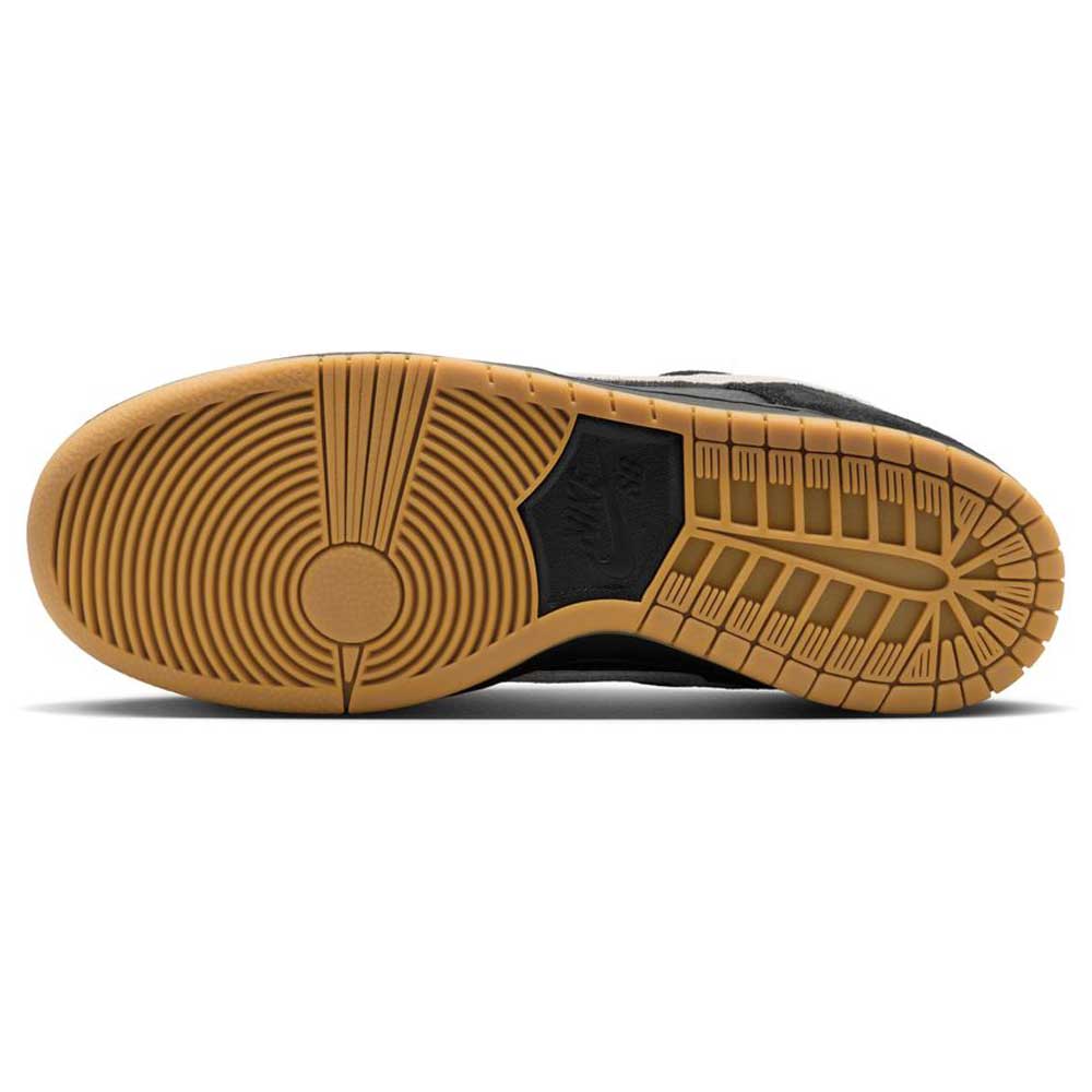 A close-up of the sole on the HF3704003 Black White Nike SB Dunk Low Pro Suede Leather Shoes shows gum rubber tread with circular and linear patterns, plus a black Nike logo in the center—ideal for skateboarding.