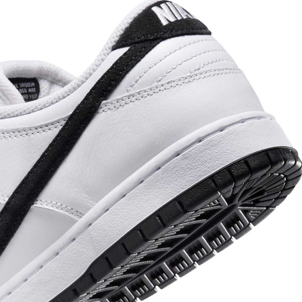 Close-up of the HF3704100 White Black Nike SB Dunk Low Pro, showing the textured rubber sole, stitched suede leather upper, black accents, and visible black Swoosh logo.