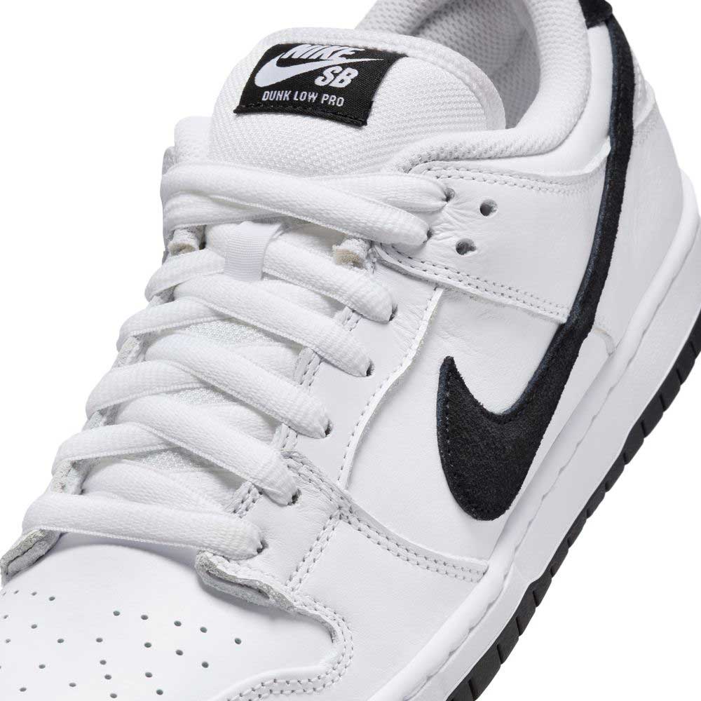 Close-up of the HF3704100 White Black Nike SB Dunk Low Pro Suede Leather Shoe, featuring black swoosh, white laces, perforated toe box, and a black and white tongue label.