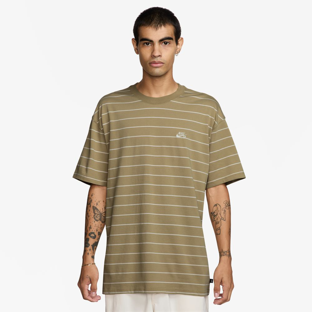 Someone wearing the HJ0812297 U NK SB TEE M90, a tan and white striped Nike SB Skateboarding tee with a small logo on the chest, stands against a plain white background.