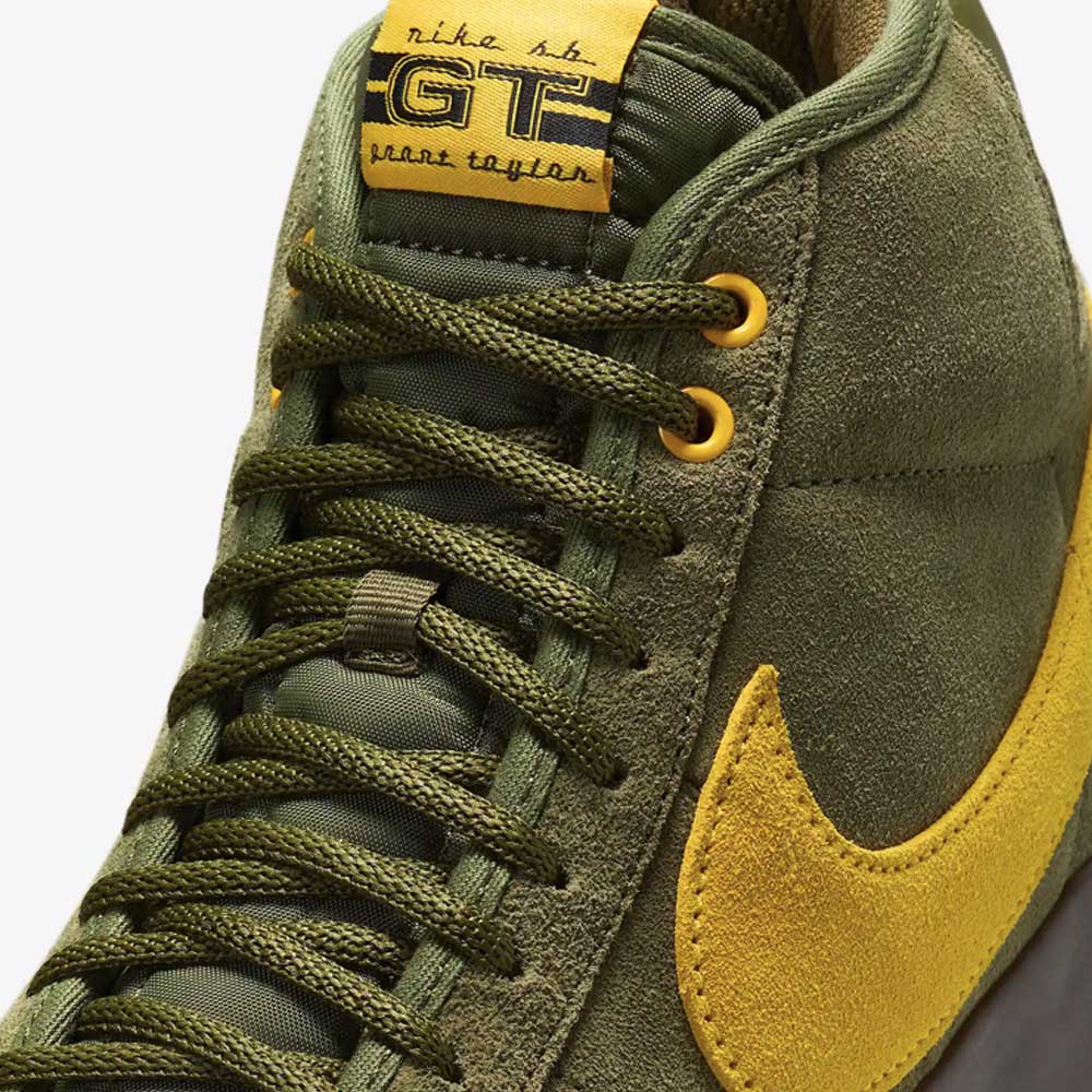 Close-up of the HM5838300 Anti Hero Rough Green Amarillo Blazer Mid Nike SB suede skateboard shoes, featuring olive green and yellow accents plus a yellow tongue label—styled for both performance and skateboarding flair.