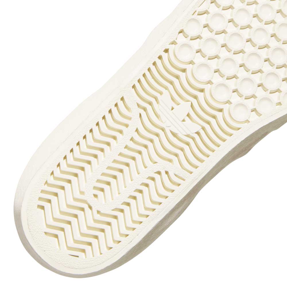 Close-up of the HQ4721 Gray White Shmoofoil Slip RX Adidas Skateboarding Suede Shoe sole, featuring zigzag lines, circular bumps, and the iconic Adidas trefoil logo embossed at the center.