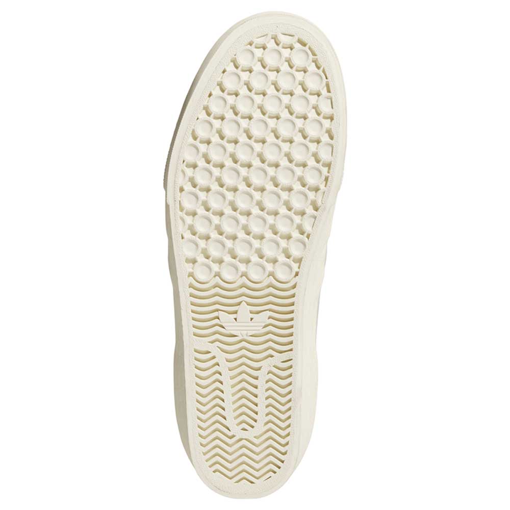 A close-up of the beige sole on the HQ4721 Gray White Shmoofoil Slip RX Adidas Skateboarding Suede Shoes, showing a textured honeycomb pattern at the top, wavy lines at the bottom, and a small central adidas logo.