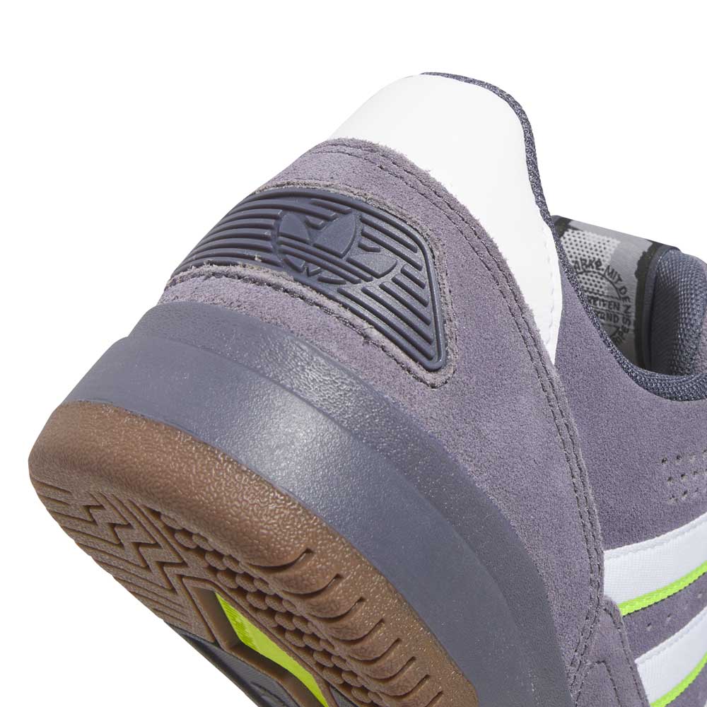 Close-up of the heel on the HQ4813 Gray White Green Tekkira Adidas Skateboarding Suede Shoe, showing gray suede, a white accent, textured brown sole, green detail, and a black rubber Adidas logo on the back.