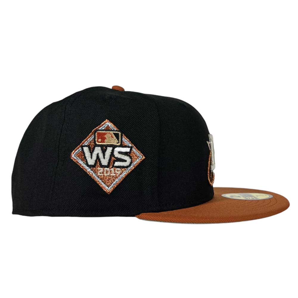 The Harvest Black Space City Houston Astros New Era 5950 Fitted Hat by Whatafitted features a brown brim, 2019 World Series patch, MLB logo above the patch, and a sticker on the top of the brim.