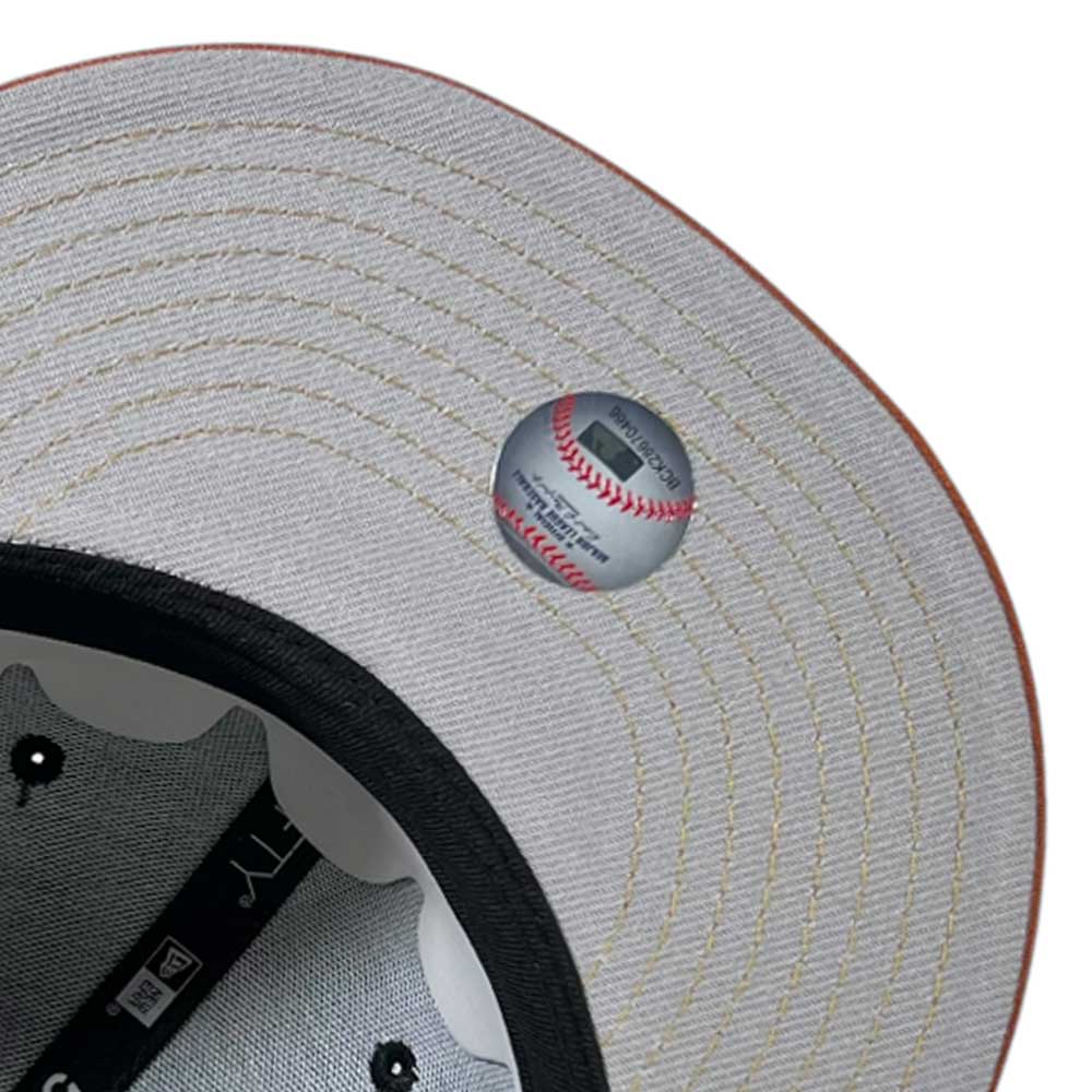 Close-up of the brim underside on the Harvest Black Space City Houston Astros New Era 5950 Fitted Hat by Whatafitted, showing tan stitching, a baseball graphic sticker, inner band, and branding details.