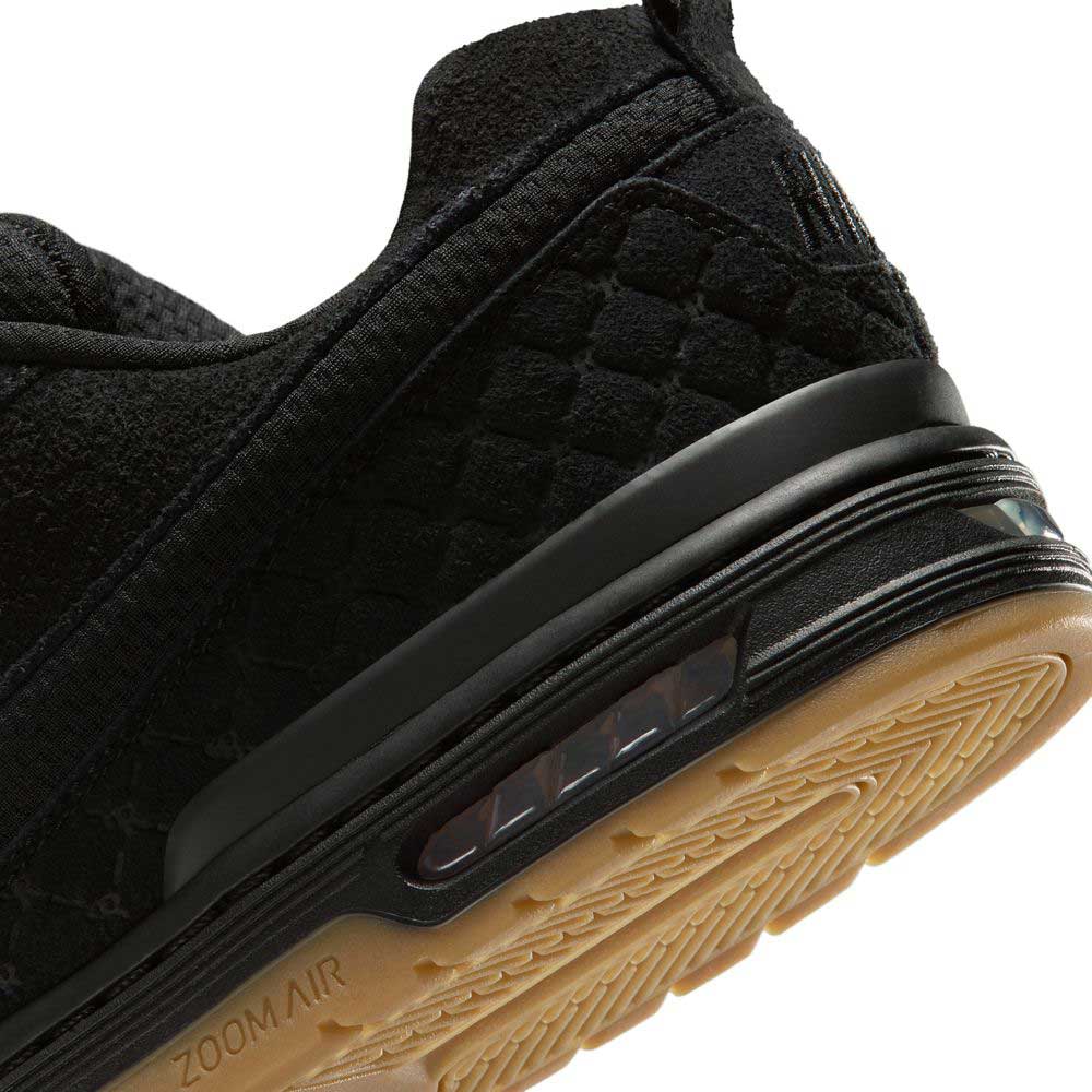 Close-up of the heel of the IQ6827001 Black Gum Light Brown Paul Rodriguez Zoom Air Low Suede Skateboarding Shoe, showing its textured black suede, visible Zoom Air cushioning, and a light brown gum outsole with a wavy tread.