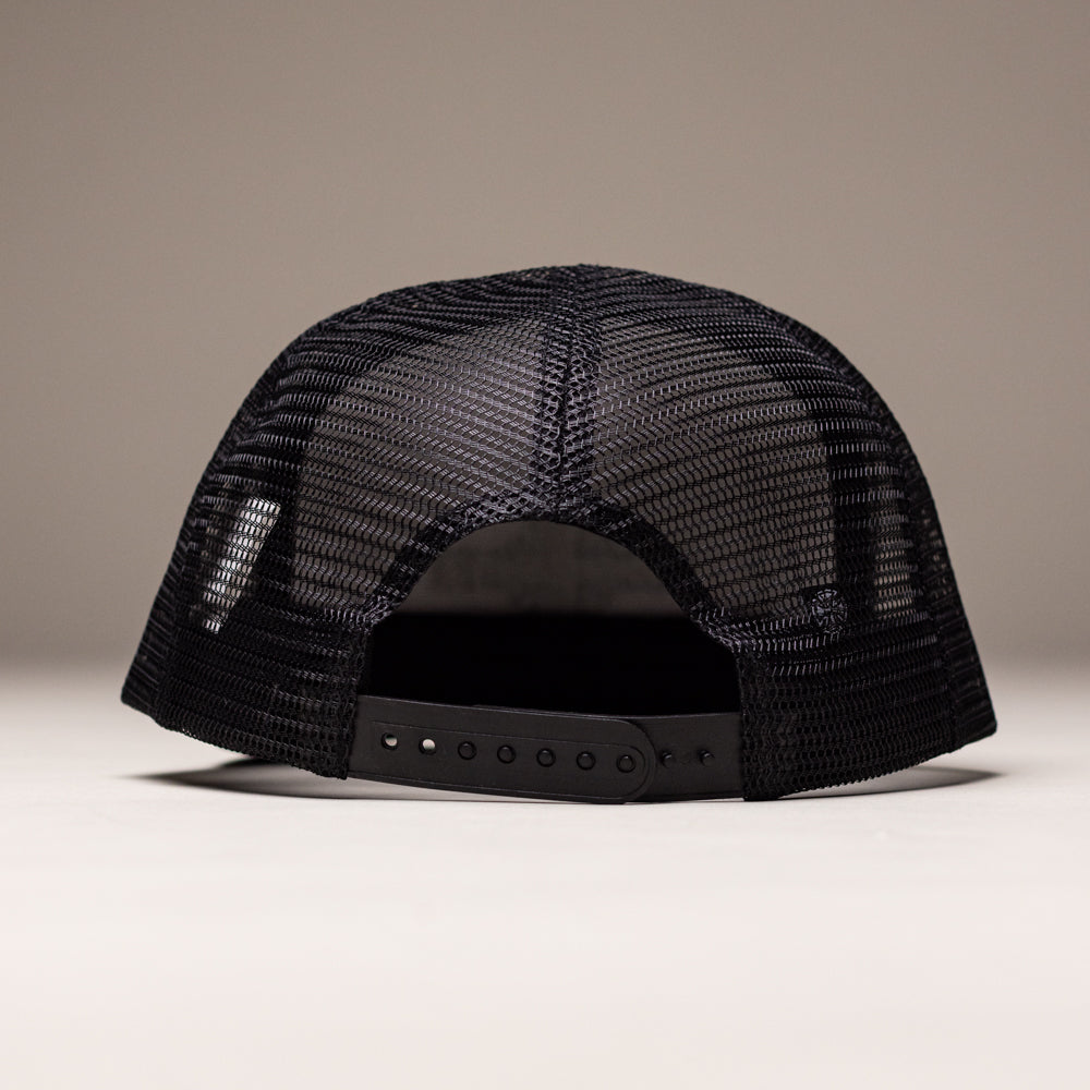 The OGBC Legacy White Dark Green Hat Shadow Snapback by Independent Skateboards is shown from the back, featuring an unstructured design and adjustable snap closure. The background is plain and neutral.