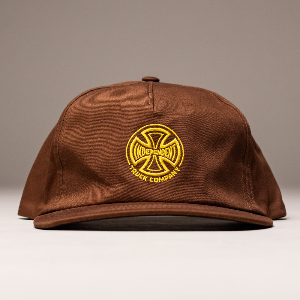 The Truck Co Legacy Brown Hat by Independent Skateboards is an unstructured tan snapback with a yellow embroidered logo and "Independent Truck Company" on the front, offering a low-profile fit.