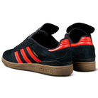 A pair of JH8134 Black Orange Gum Busenitz Adidas Skateboarding Suede Shoes with black uppers, orange stripes and heel accents, and brown gum soles. The left shoe is shown from the side, the right from the back.