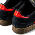 Close-up of JH8134 Black Orange Gum Busenitz Adidas Skateboarding Suede Shoes, showing black suede, orange accents on the heel, and brown textured rubber soles with the Adidas logo.