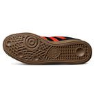 The image displays the gum rubber sole of the JH8134 Black Orange Gum Busenitz Adidas Skateboarding Suede Shoe, featuring a unique textured pattern with an adidas logo at the center and glimpses of its black and orange suede upper.