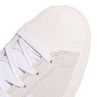 Close-up of the JH8141 White Silver White Pro Shell Mid Trainers ADV Adidas, showing a textured rubber toe cap, white laces, suede upper with visible stitching—skateboarding shoes inspired by vintage basketball style.