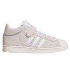The JH8141 White Silver White Pro Shell Mid Trainers ADV by Adidas feature beige suede uppers, a white rubber sole, white toe cap, white laces, three white side stripes, and a Velcro strap, blending vintage basketball style with skateboarding performance.