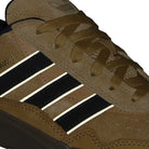 Close-up of the JI0851 Mesa Black Gum Tyshawn 2 II Adidas shoe, featuring leather and suede, three black and white side stripes, textured stitching, and cupsole construction for grip and durability—showcasing classic skateboarding style.