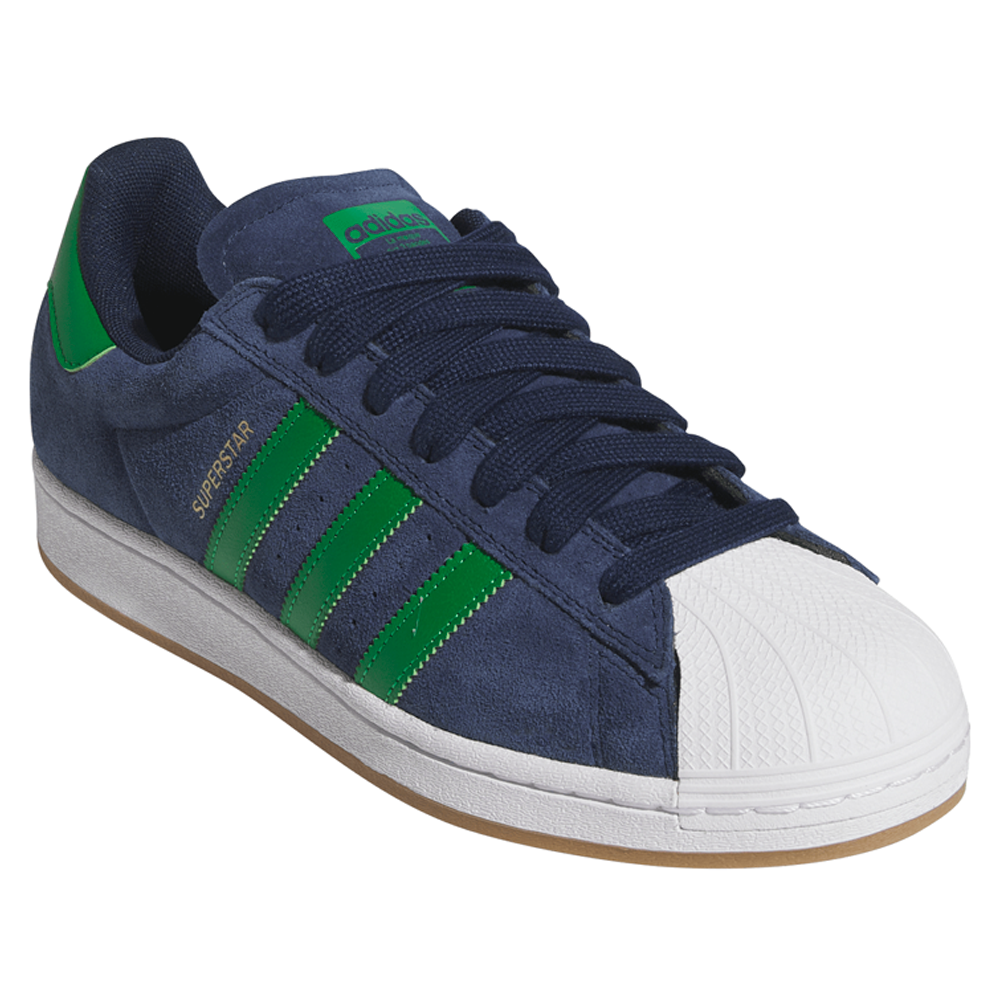 The JQ2098 Navy Green White Superstar ADV Adidas Suede Skateboarding Shoe features a navy blue suede upper, green stripes and heel tab, white rubber shell toe, dark blue laces, tan sole, and durable cupsole construction with gold SUPERSTAR branding.