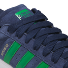 Close-up of JQ2098 Navy Green White Superstar ADV Adidas suede skateboarding shoes featuring a green Adidas tongue label, green stripes, yellow "SUPERSTAR" text, dark blue laces, and durable cupsole construction.