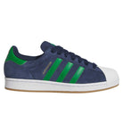 The JQ2098 Navy Green White Superstar ADV Adidas Suede Skateboarding Shoes feature green stripes, a white shell toe, dark blue laces, tan rubber sole, and durable cupsole construction, shown in side profile view.