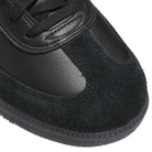 Close-up of the JR2059 Black Black Samba ADV Adidas Skateboarding Shoes, showcasing smooth leather and textured suede uppers, black laces, a molded sockliner, and a ridged rubber sole.