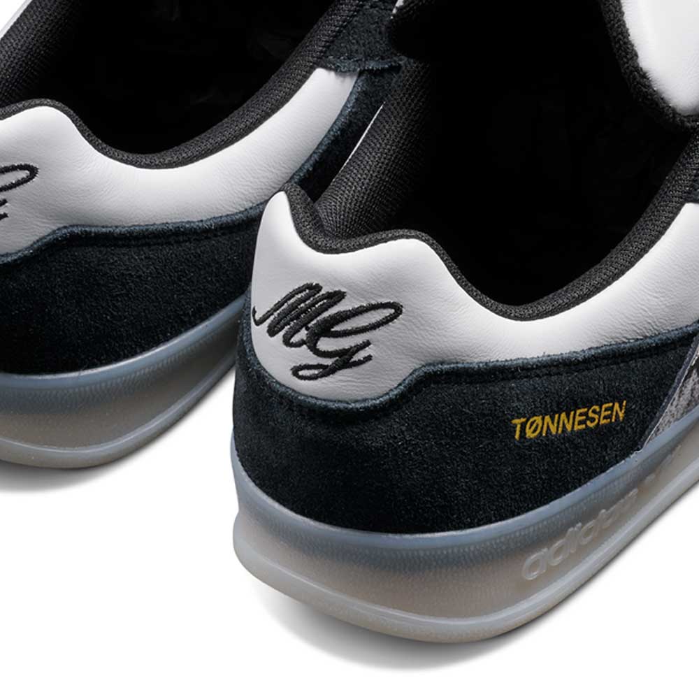 Close-up of the JR7101 Gustav Tonnesen Black White Aloha Super suede leather skateboarding shoes, featuring "M G" embroidery and gold "TØNNESEN," highlighting this adidas Skateboarding collaboration.