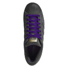 Top view of the JR7409 Carbon Purple Superstar ADV Adidas suede skateboarding shoes, featuring black uppers, carbon purple suede laces, and a gold Adidas logo on the tongue.