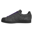 The JR7409 Carbon Purple Superstar ADV Adidas Suede Skateboarding Shoes feature a dark gray, textured surface, black rubber toe cap and sole, Carbon Purple suede laces, and subtle side stripes for classic style.