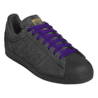 The JR7409 Carbon Purple Superstar ADV Adidas suede skateboarding shoes feature a textured carbon purple upper, black sole, gold tongue label, and bright purple laces.