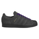 The JR7409 Carbon Purple Superstar ADV Adidas Suede Skateboarding Shoes feature a dark gray suede finish, black rubber toe cap and sole, gold “Superstar” text, and purple laces—ideal for skateboarding enthusiasts.