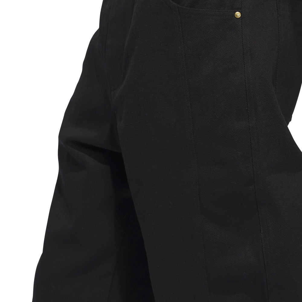 Close-up of the upper legs and hip area of a person wearing the JX6827 Black Kader Sylla Pant Adidas, featuring a visible pocket and a small gold rivet detail near the pocket seam.