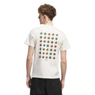 A person with short, light brown hair is seen from behind wearing the JY3958 Skate Tee in Wonder White/Rustic Orange by Adidas Skateboarding, featuring colorful trefoil logos on the back, paired with black shorts.