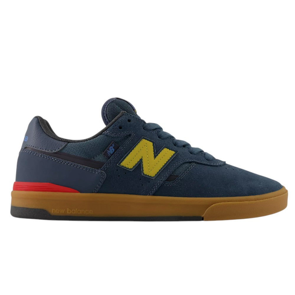 Jamie Foy Cup 306 CON New Balance Numeric suede skateboarding shoes in navy blue with a yellow logo, red heel accent, and a brown rubber sole.