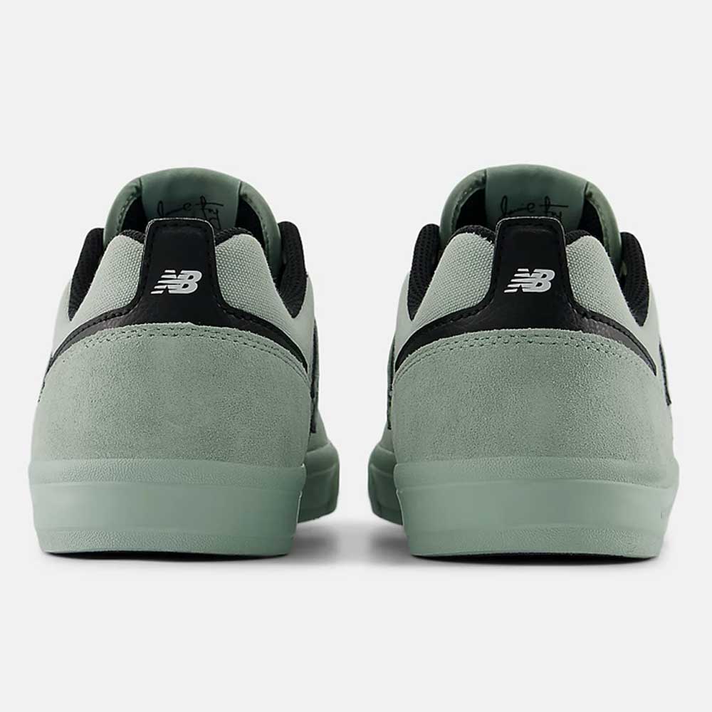A pair of Mosaic Green Black Jamie Foy Mint 306 MOG New Balance Numeric suede skateboarding shoes seen from the back, with suede heels, black accents, and white logos—an ideal vulcanized shoe for skating.