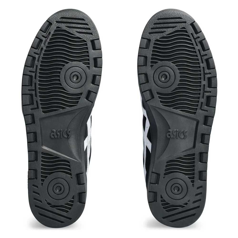 The Japan Pro Asics Black White 1201A92001 Suede Skateboarding Shoes feature two black rubber soles with textured grip and circular patterns, raised ASICS Japan Pro logos at the center, and partially visible white side stripes.
