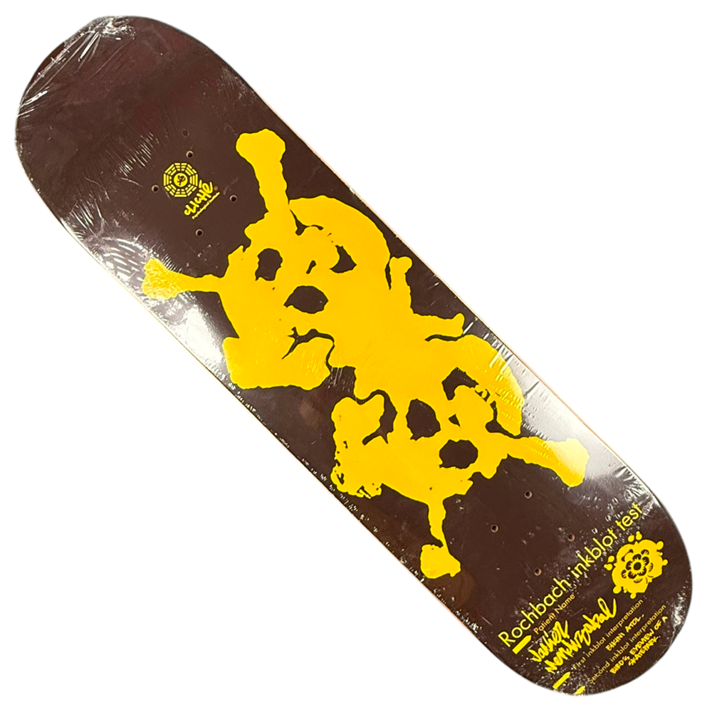 The Javier Mendizabal Inkblot Cliche Deck 8x31.9 Collectible features a brown background with a bold, abstract yellow skull-inspired graphic and yellow text/logos in the corner—a standout skateboard deck from Cliché.