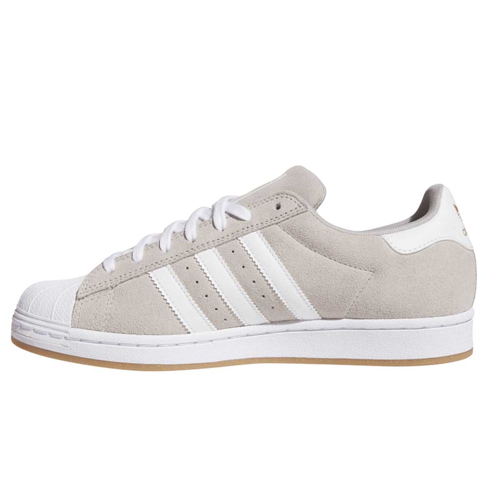 The KI5733 Gray White Superstar ADV Adidas Skateboarding Shoes feature light gray suede, white laces, a white rubber toe cap, three white side stripes, and a white sole with a light brown bottom for classic skate style.