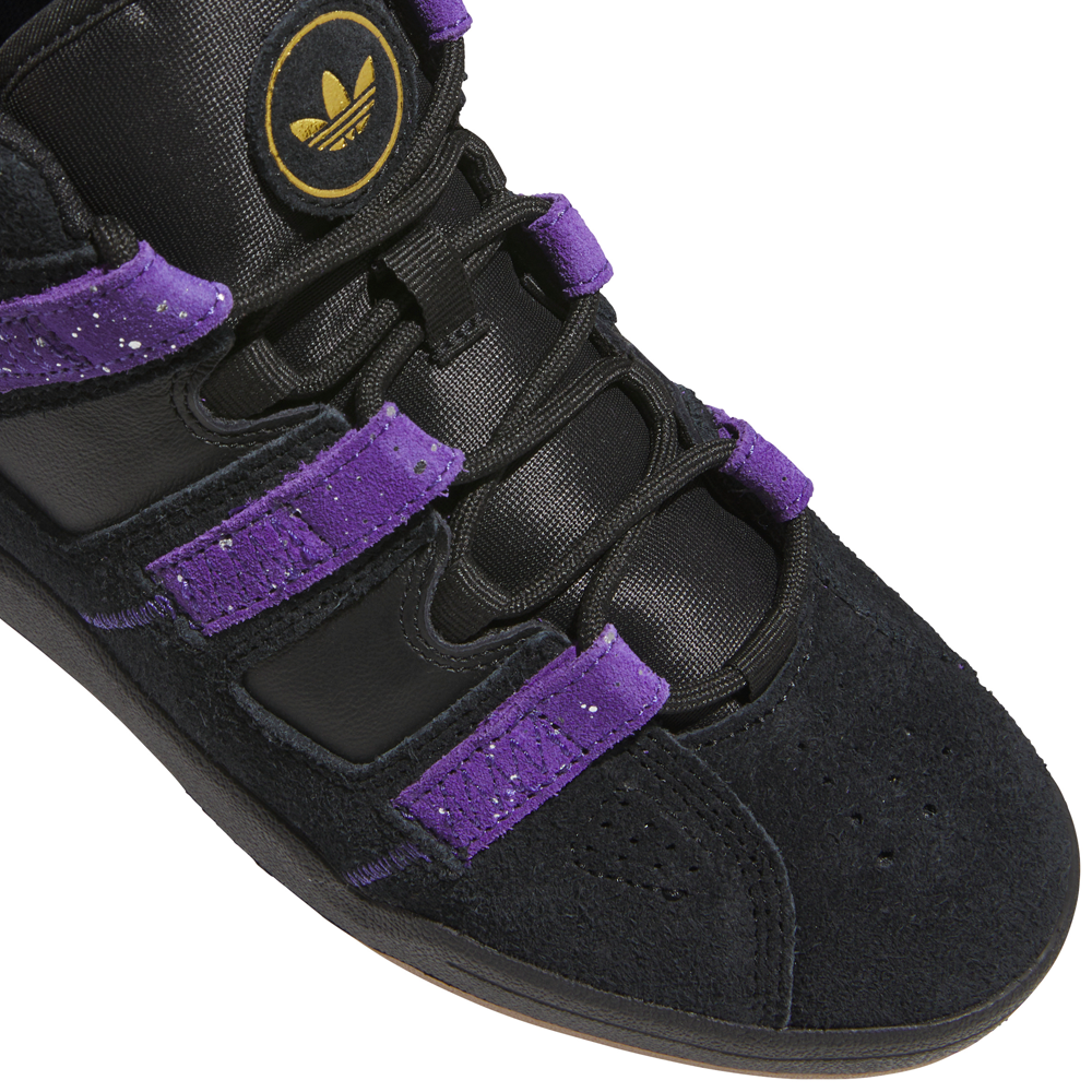 Close-up of a black and purple Kader Black Purple KI0408 Adidas Skateboarding Suede Leather shoe with suede overlays and a circular gold logo on the tongue.