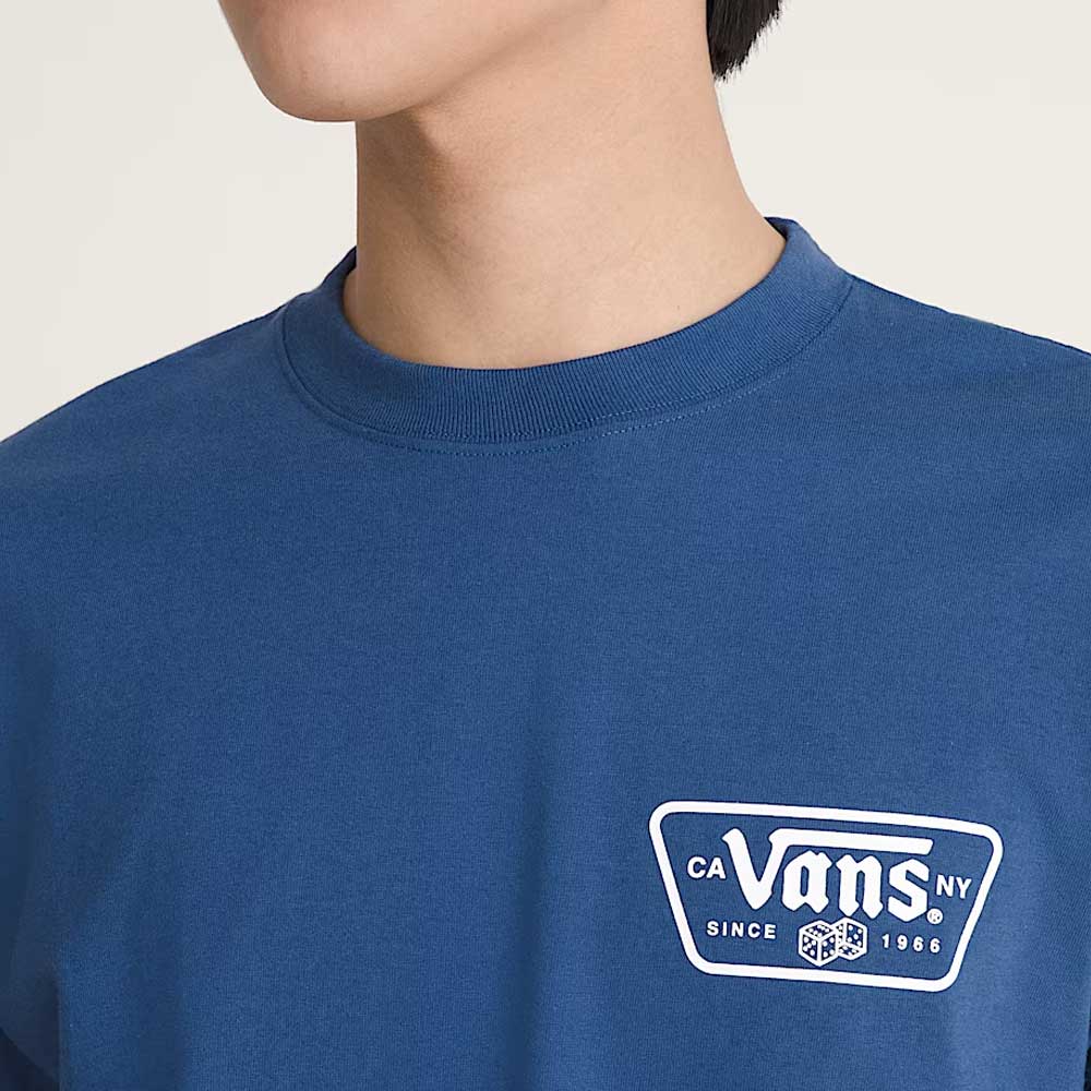 A person wearing the Vans Skateboarding Knu Patch VN000WU85TU1 True Navy Blue Short Sleeve Tee, 100% cotton, with a white patch logo on the left chest. The image shows their upper torso and lower face.