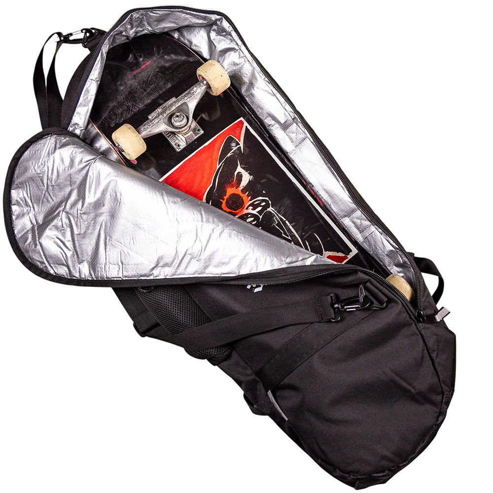 A Southside x Kyoto Board Bag in gray ripstop with reflective details lies open, showing a skateboard with black and red graphics inside; the deck’s artwork and wheels are partially visible.