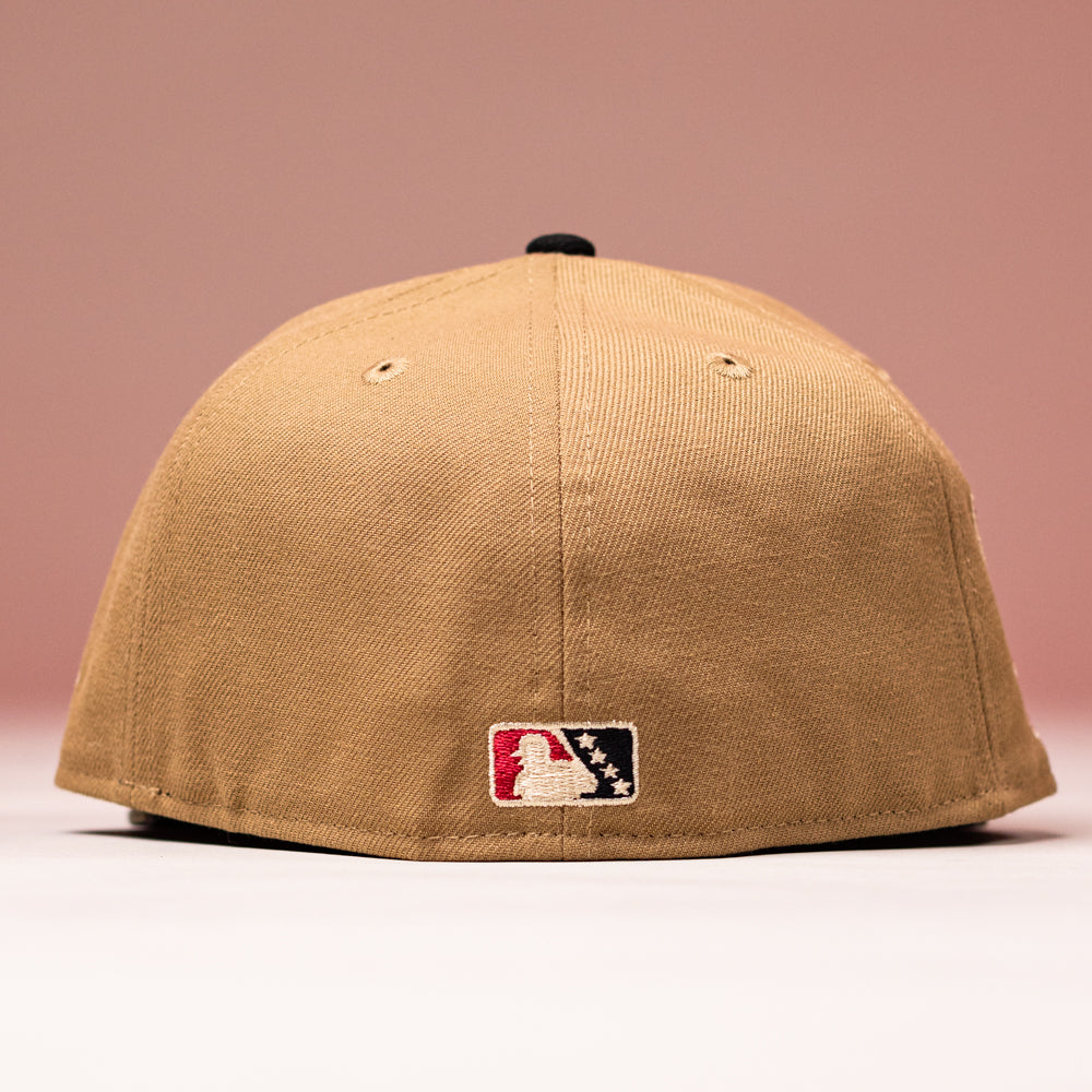 A La Ofrenda Khaki RTC Copa Corpus Christi Hooks New Era 5950 Fitted hat viewed from the back, featuring the MLB logo patch at the bottom center, set against a soft pink background.