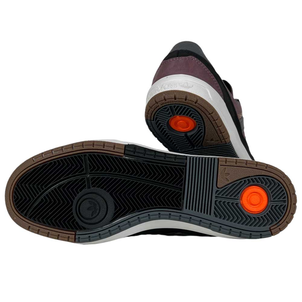 A pair of Lavandar Gray Black Tyshawn 2 II Adidas Skateboarding Leather Suede Shoes is shown from the bottom, highlighting the black and brown rubber soles with orange circular details near the heel.